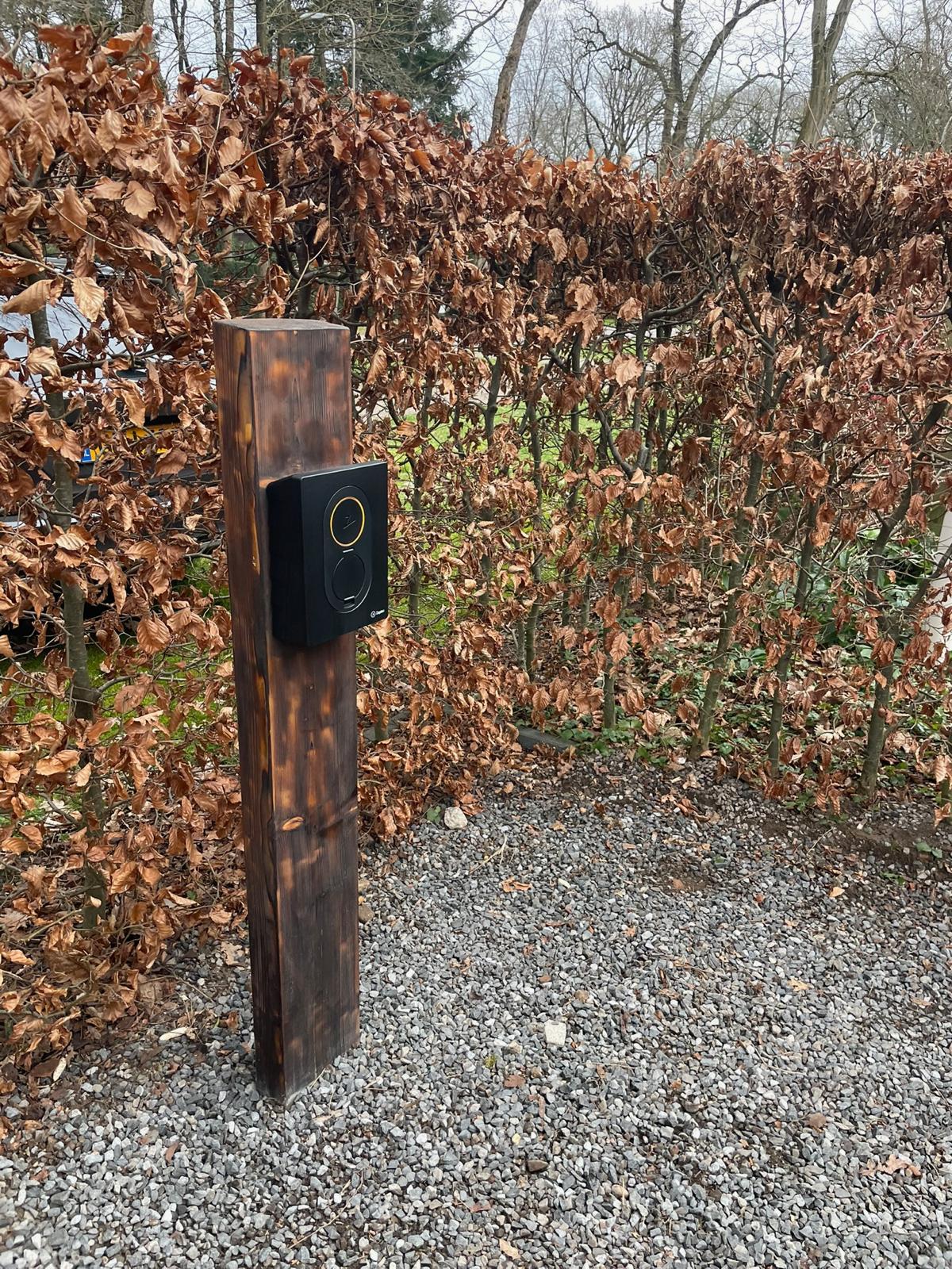 Laadpaal van Nuzon gemonteerd op een houten gevel