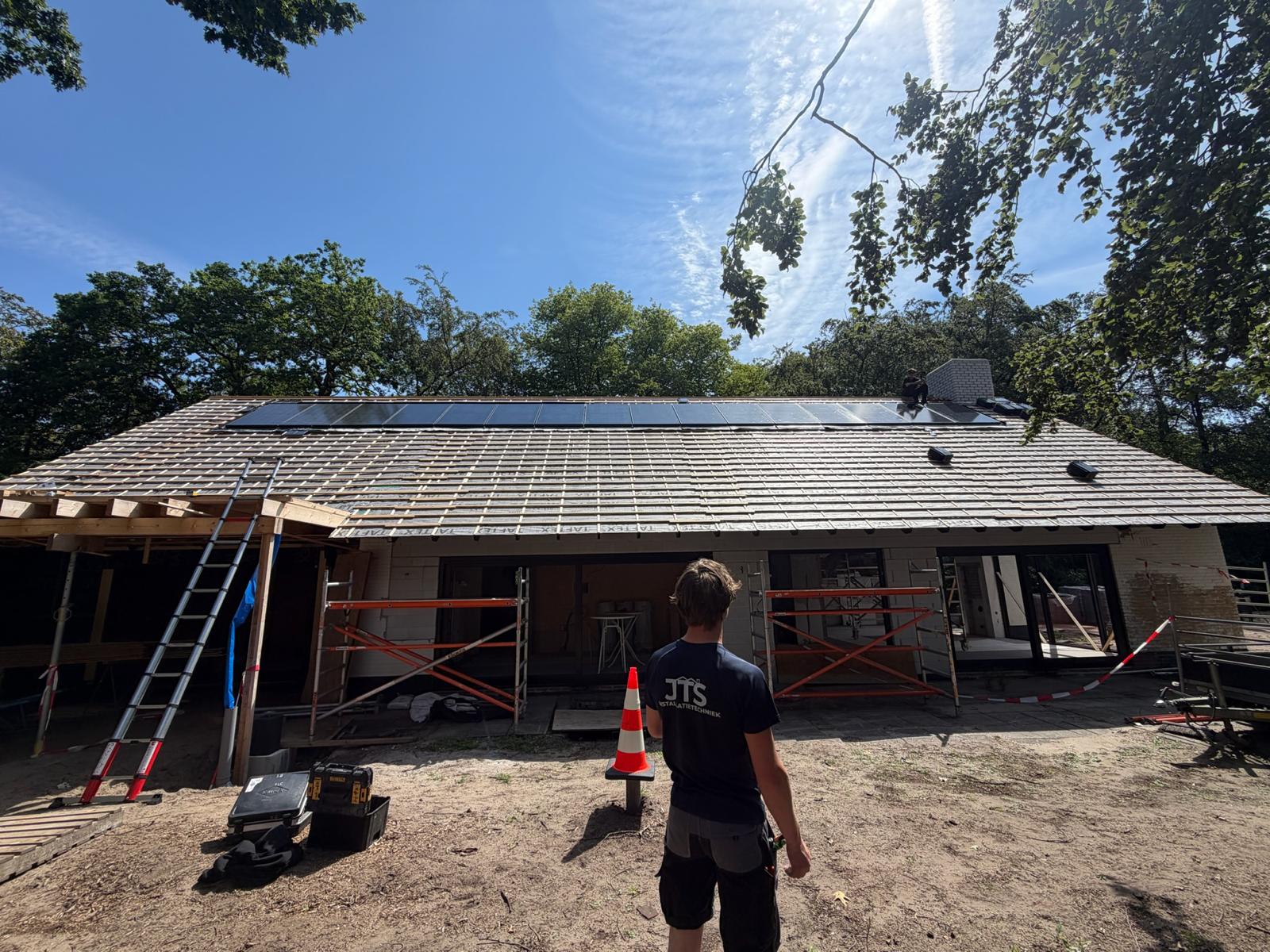 Panelen op het pannendak van een woning in aanbouw