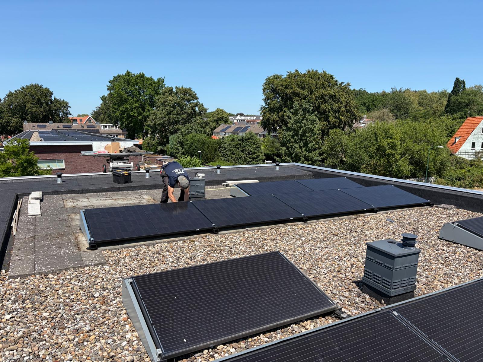 Full-black panelen in opstelling op een plat grinddak