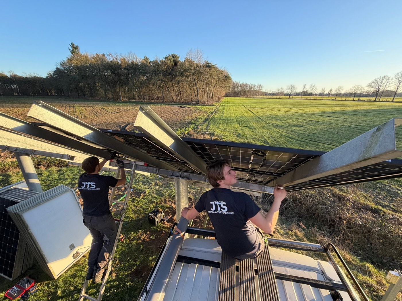 JTS-monteurs monteren zonnepanelen op het aangepaste frame van de grondopstelling